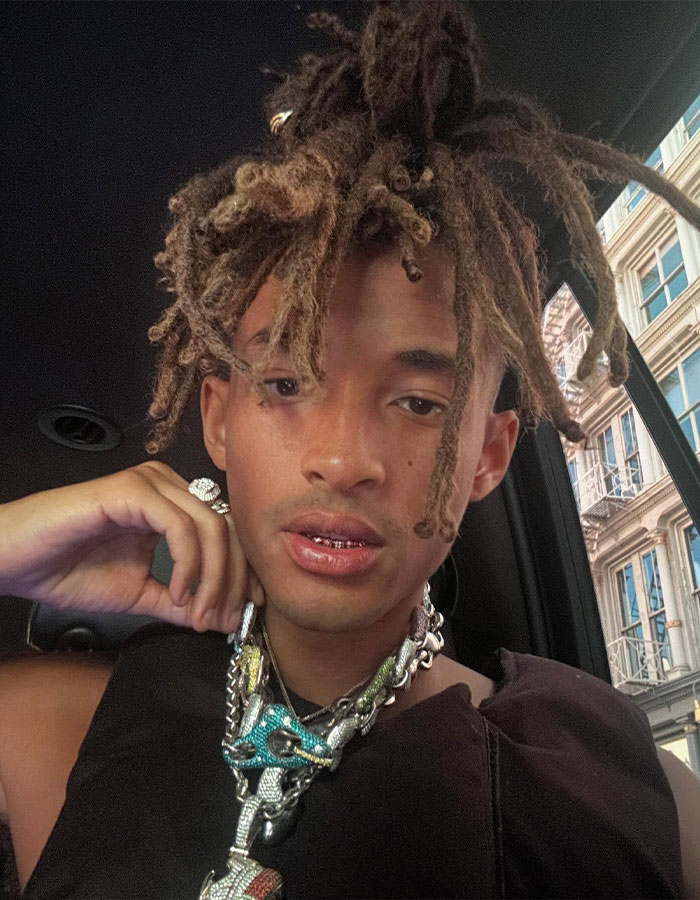Jaden Smith wearing layered chains and rings, showing a red-faced look with dreadlocks inside a car near Paris windows. Jaden Smith wearing layered chains and rings, showing a red-faced look with dreadlocks inside a car near Paris windows.