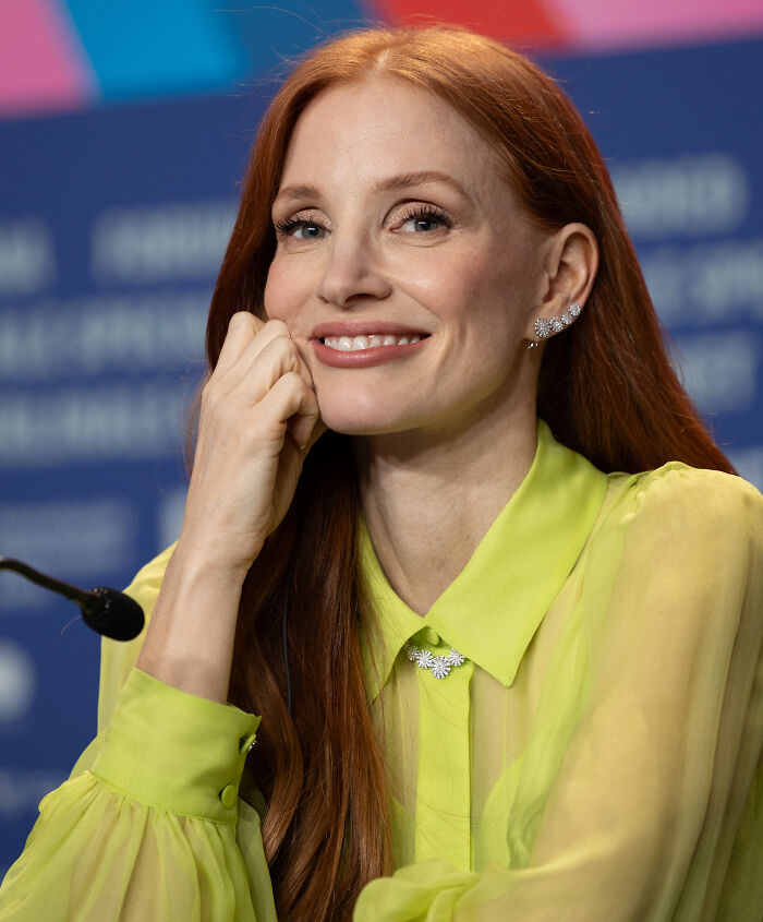 Red-haired Hollywood star smiling during a press event, showcasing actors who found fame after 30 years old.