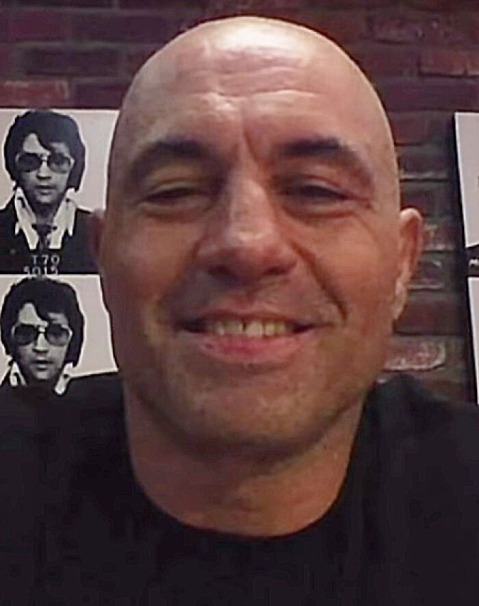 Bald man smiling in front of brick wall with black and white celebrity photos, related to celebs people can't stand.