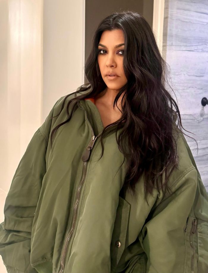 Kourtney Kardashian wearing a green jacket, posing indoors related to lollipops for women&rsquo;s private parts launch.