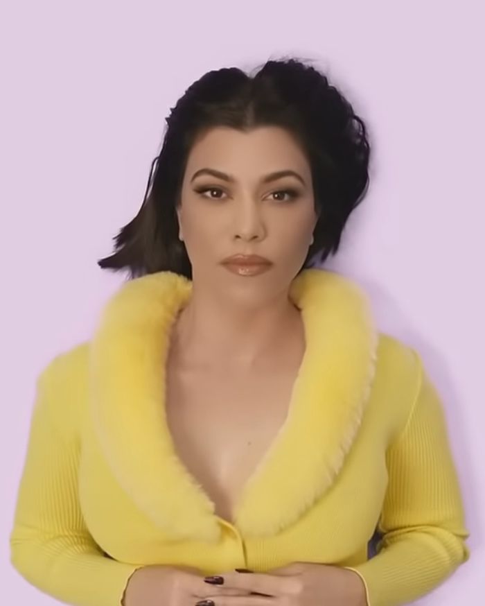Kourtney Kardashian posing in a yellow outfit promoting lollipops for women&rsquo;s private parts product launch.