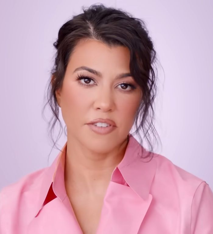 Kourtney Kardashian in a pink blouse with natural makeup, promoting lollipops for women&rsquo;s private parts concept.