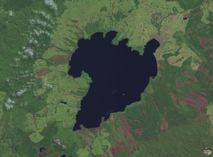 Satellite image of a large lake surrounded by green landscapes showing unbelievable facts about countries that are actually true
