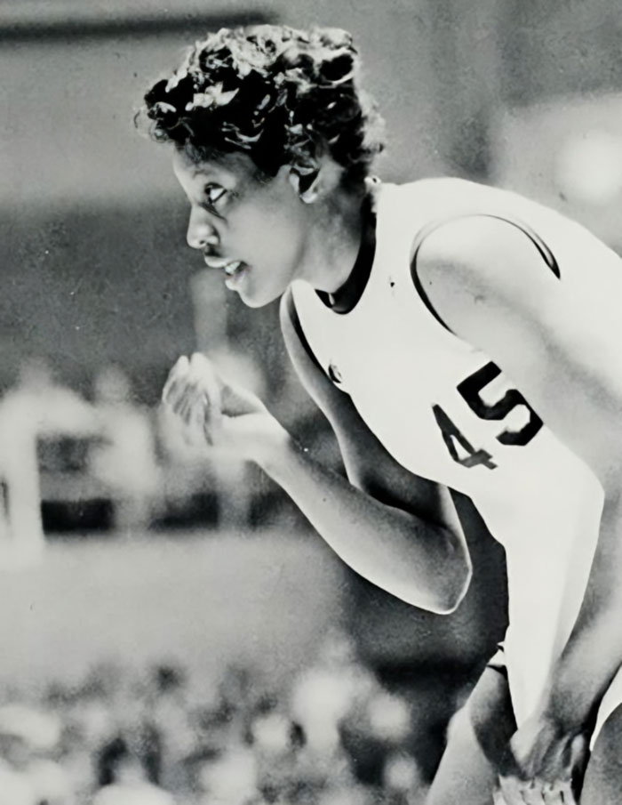Black and white photo of a female basketball player wearing jersey number 45 focused on the game.