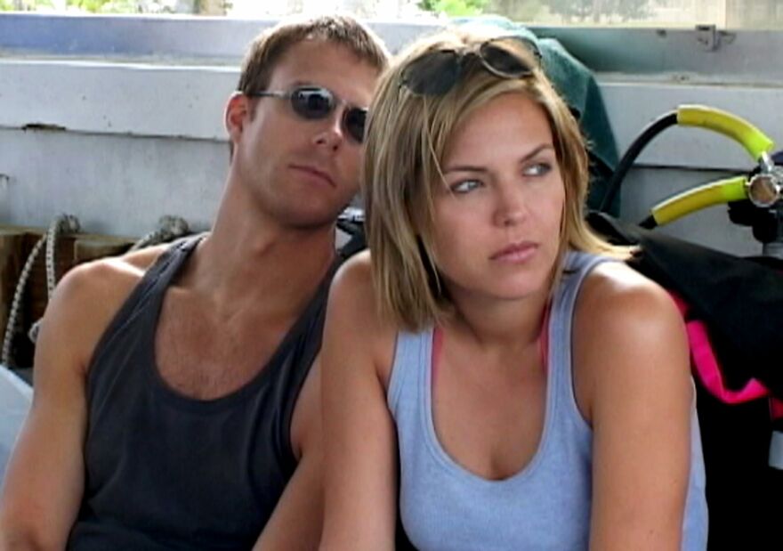 Two people sitting closely, wearing casual summer clothes, representing movies based on true stories that feel impossible.