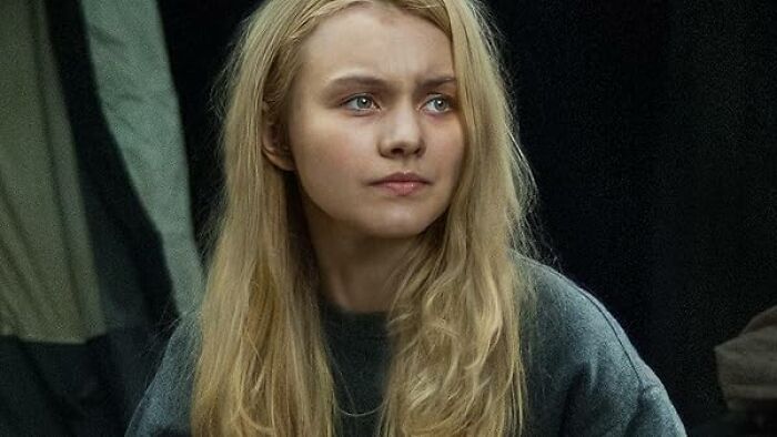 Young woman with long blonde hair looking thoughtful in a scene from movies based on true stories that feel impossible to believe