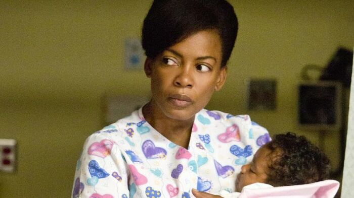 Actress holding a baby in a hospital setting, a scene from movies based on true stories that feel impossible to believe.