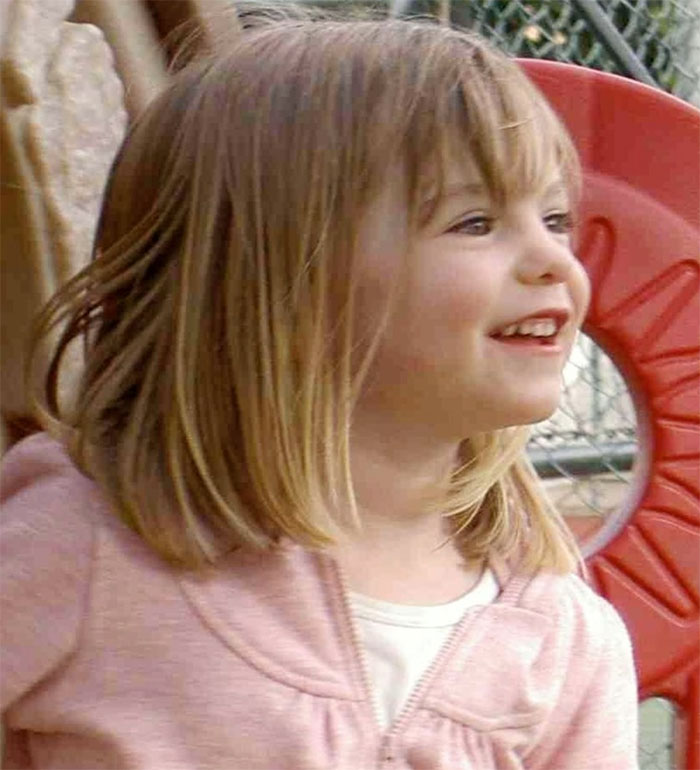 Young girl who believed she was Madeleine McCann smiling outdoors near playground equipment during court testimony.