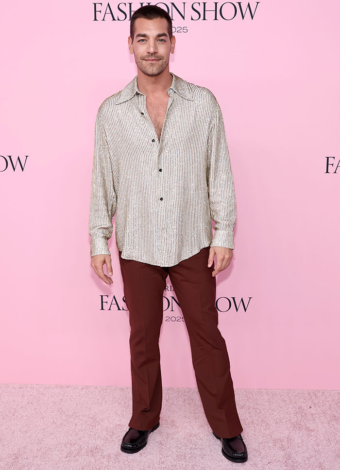 Man wearing a shiny striped shirt and brown pants at the Victoria's Secret Fashion Show 2025 risqué looks event.