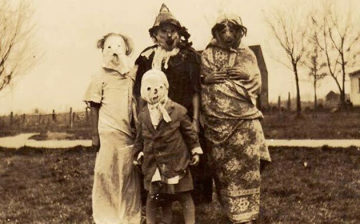 Vintage Halloween costumes from the past featuring eerie and impressive handmade masks in an outdoor rural setting.