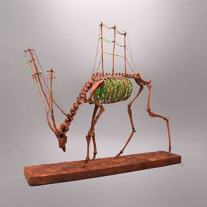 Porcelain sculpture of a skeletal mythical creature with green foliage inside, resembling relics of forgotten myths.