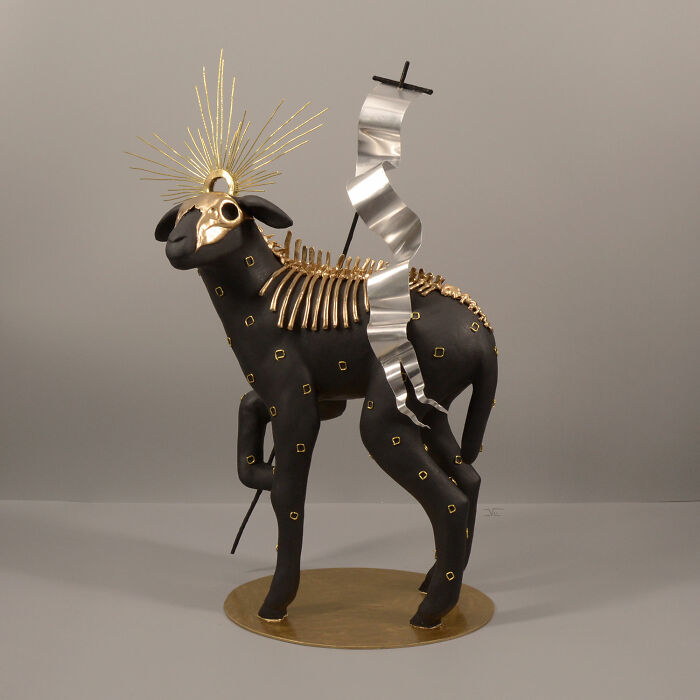 Porcelain sculpture of a black animal with gold accents and metallic elements, resembling a relic from forgotten myths.