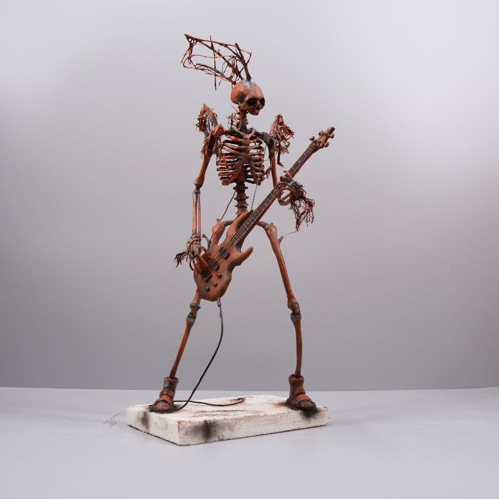 Porcelain sculpture of a haunting skeletal figure playing guitar, resembling relics of forgotten myths and ancient tales.