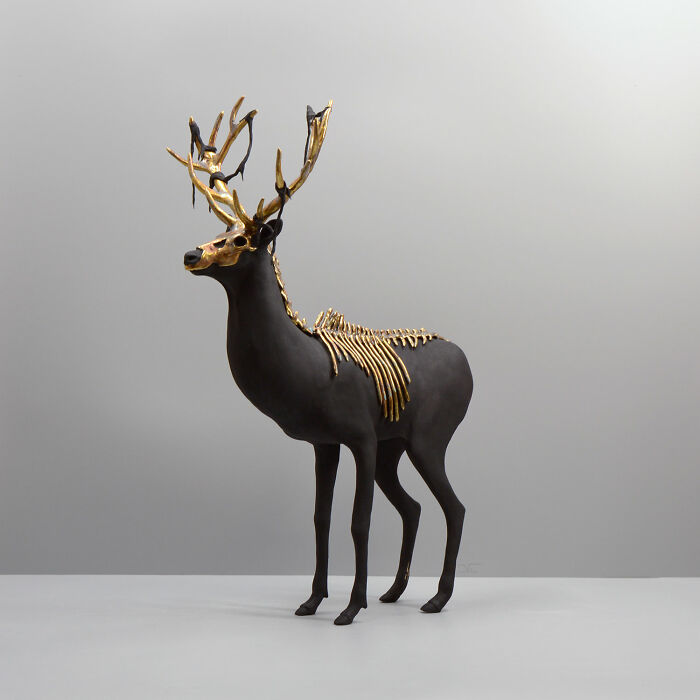 Porcelain sculpture of a haunting stag with gold antlers and skeletal details, resembling relics of forgotten myths.