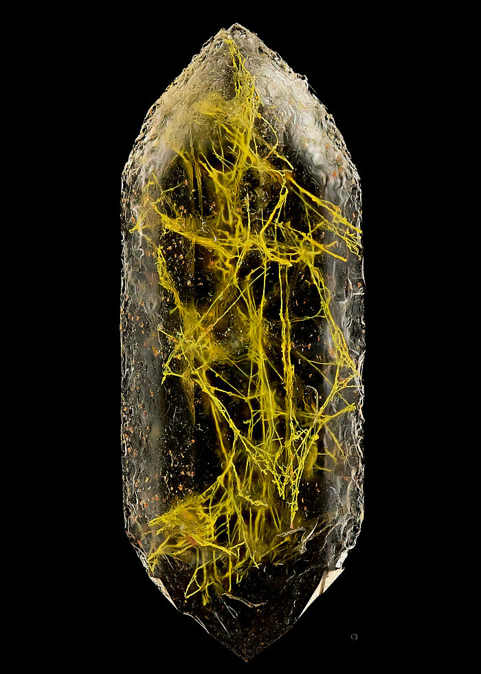 Microscopic image showing intricate yellow mineral filaments inside a crystal from the 2025 Nikon Small World contest.