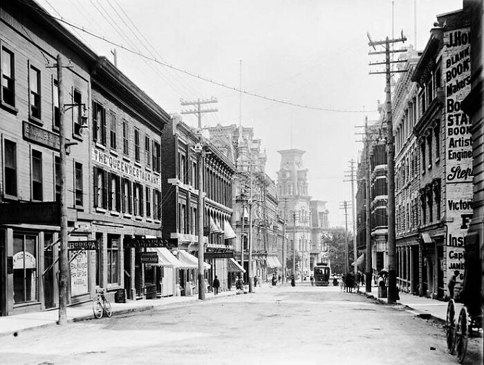 Historic black and white photo of a world capital street scene showing architecture and early urban life before modern times.
