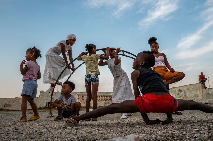 Children playing and stretching on a rooftop, captured in vibrant pure street photography awards style.