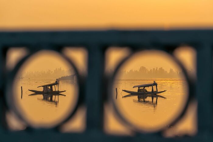 Boat on calm water at sunset framed by geometric patterns, showcasing soulful street photography moments.