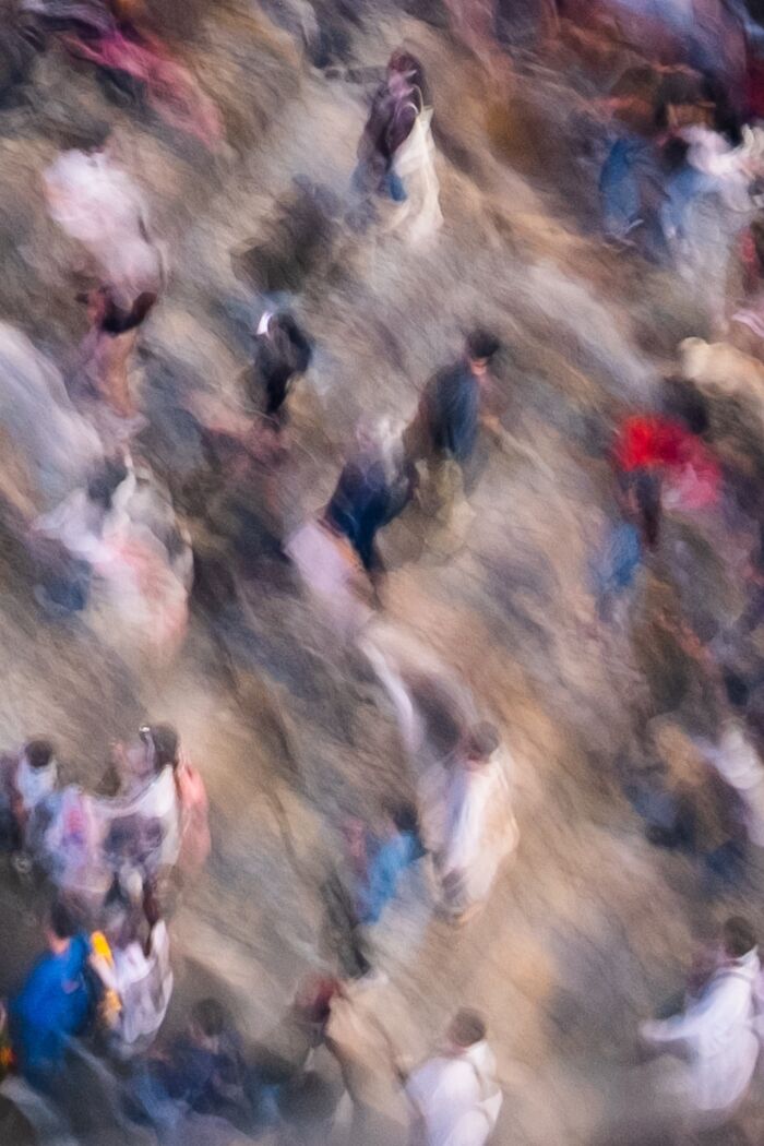 Blurry street scene of people walking, showcasing dynamic motion in pure street photography awards image.