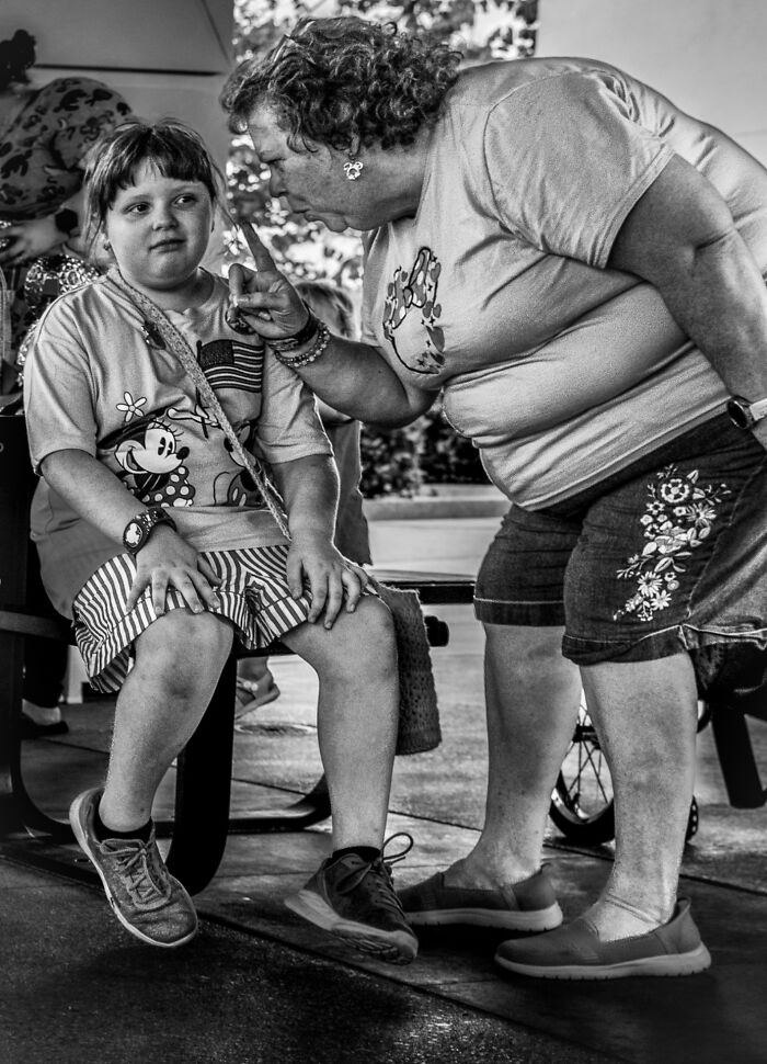 Black and white street photography showing a woman scolding a child, capturing raw emotion and interaction on the street.
