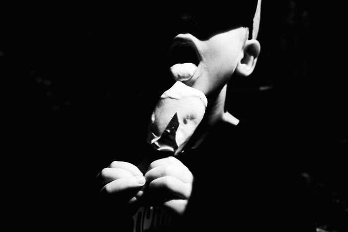 Child licking ice cream in low light, a striking example of pure street photography capturing everyday moments.