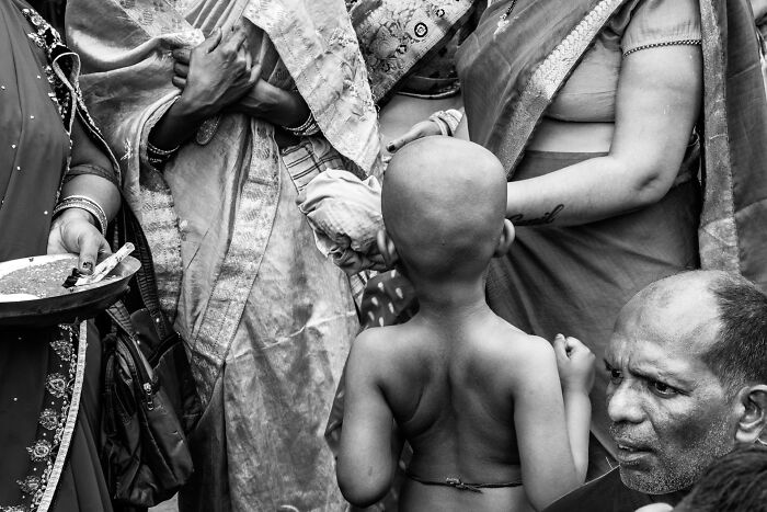 Black and white street photography capturing candid moments of people in traditional clothing during a cultural gathering.