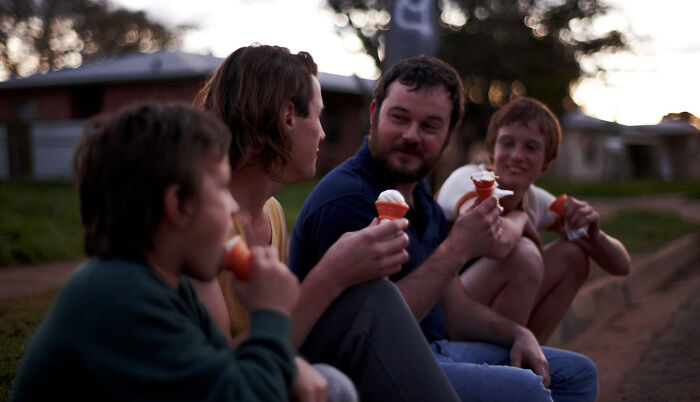 Four people sitting outdoors eating ice cream, a scene from movies based on true stories that feel impossible to believe.