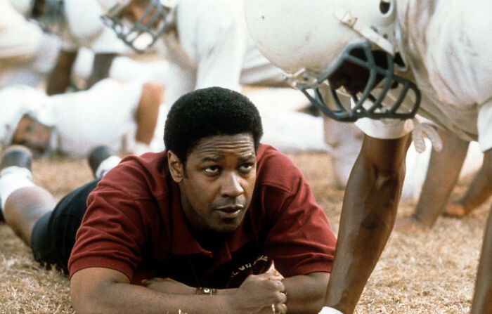 Actor coaching football players during a practice scene in one of the movies based on true stories that feel impossible to believe.