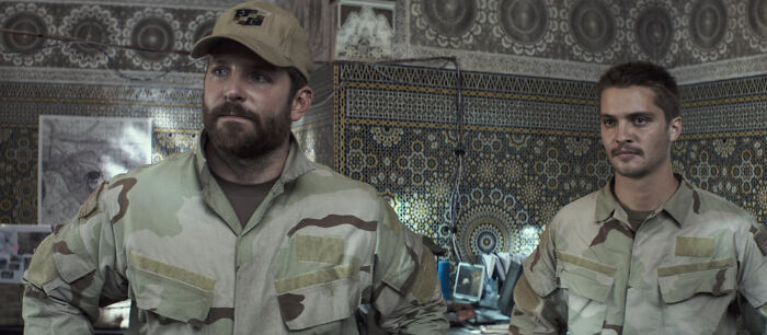 Two men in military uniforms inside a room, representing scenes from movies based on true stories.