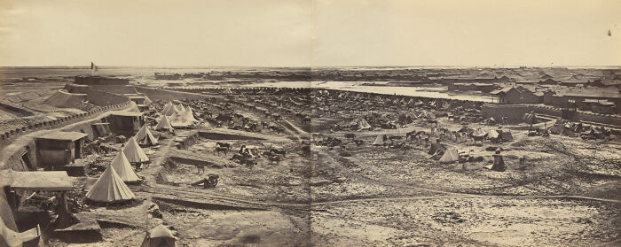 Panoramic photo showing an early settlement with tents and simple structures in a world capital before modern times.