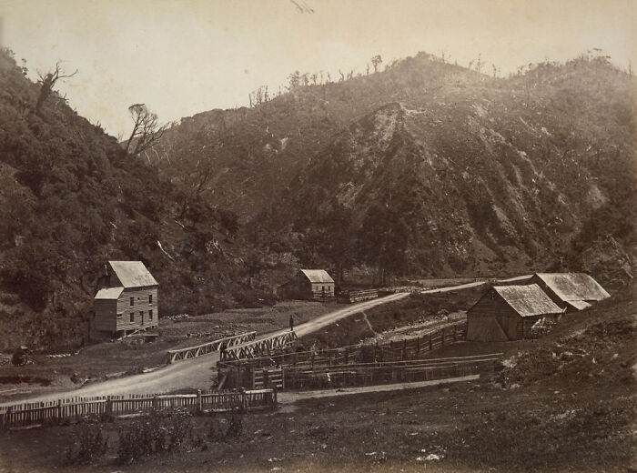 Rural scene with old wooden houses and a bridge in a valley, showing what the world’s capitals looked like before modern times.