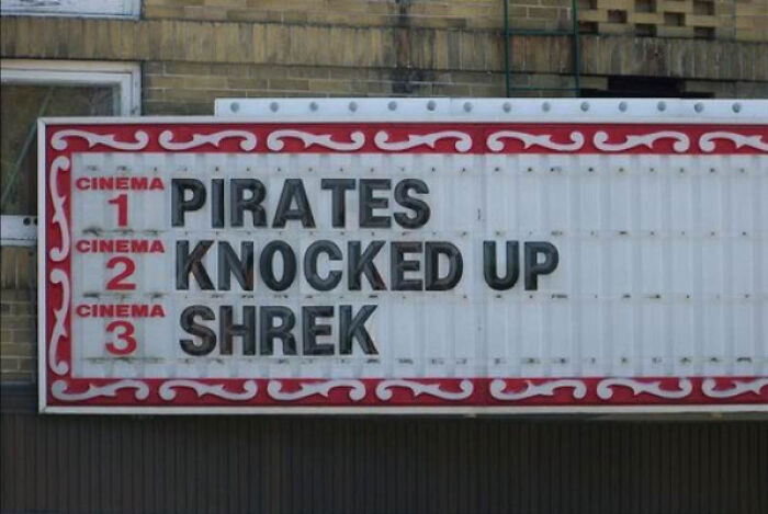 Marquee sign with humorous movie titles pirates knocked up and Shrek, showcasing accidental comedy in public spaces.