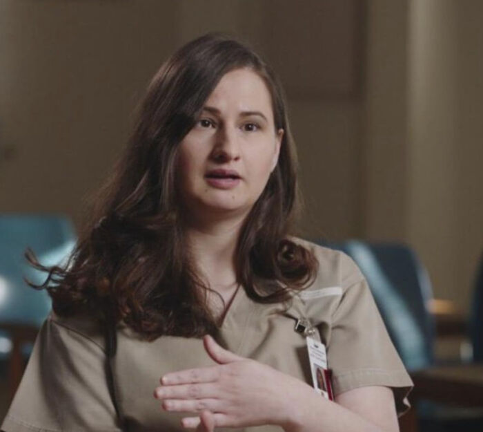 Woman in tan prison uniform speaking during an interview, representing true crime fans discussing cases.