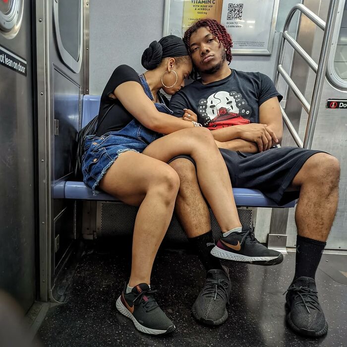 Young couple resting together on a New York City subway bench, showcasing intimate NYC subway street portraits.