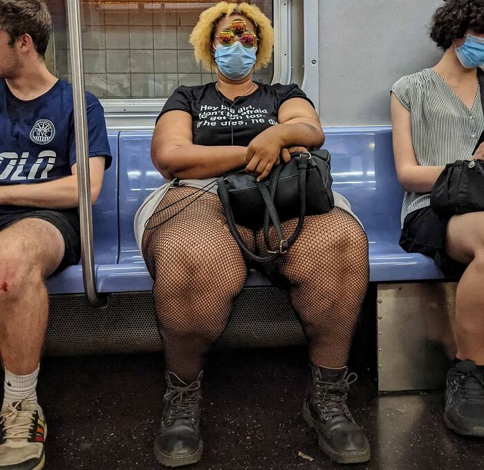 Woman wearing fishnet stockings and mask sitting on NYC subway, part of captivating street portraits from life underground.