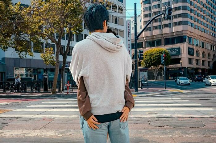 Street photographer captures humor and chaos in everyday life with a creative shot of a person wearing a hoodie in the city.