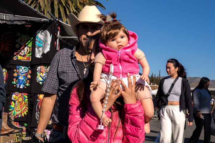 Street photographer captures humor and chaos in everyday life with vibrant market scene and people interacting under bright sunlight.