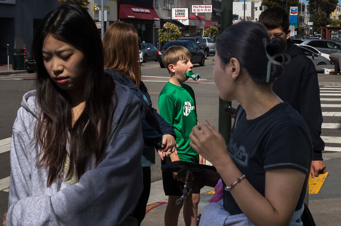Street photographer captures humor and chaos in everyday life with candid moments of people on a busy city street.