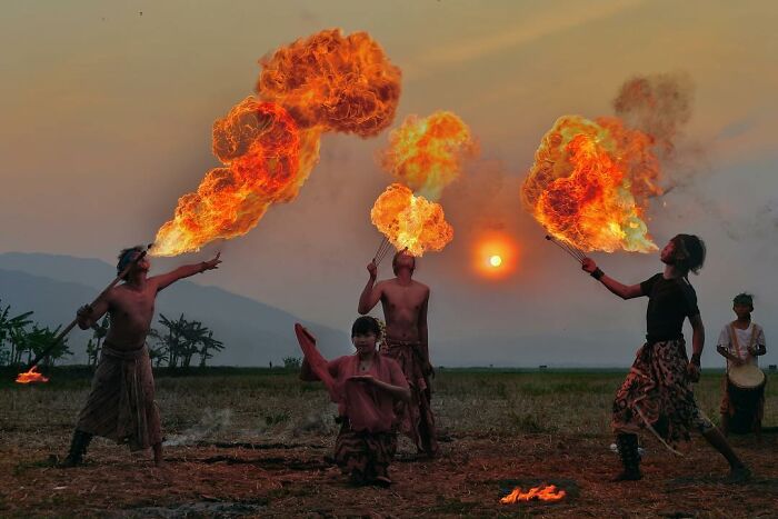 Fire performers captured at sunset in a candid photo showcasing life’s beauty through Harjanto Sumawan’s lens.