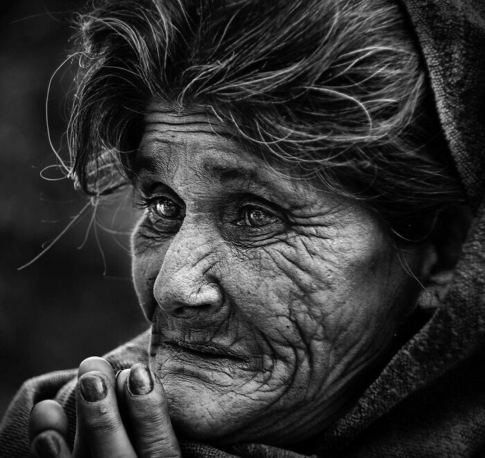 Black and white candid portrait of an elderly woman capturing life’s beauty through Harjanto Sumawan’s lens.
