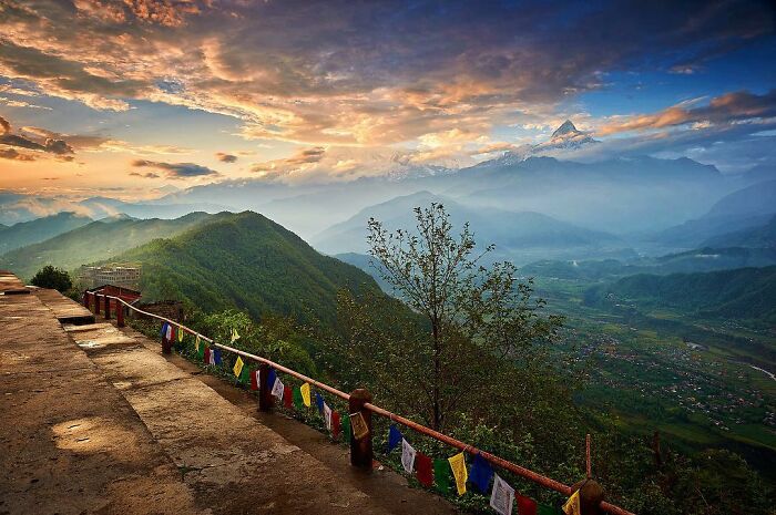 Mountain landscape at sunrise with colorful prayer flags, showcasing candid photos that capture life’s beauty.