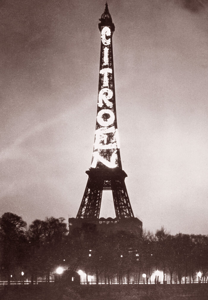 Eiffel Tower at night with illuminated Citroën advertisement showcasing early 20th century historic marketing landmark.