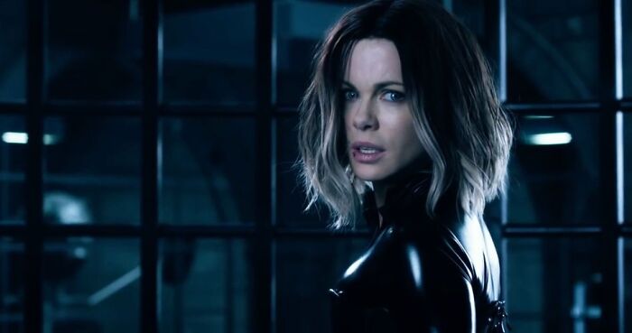 Woman in a black leather outfit in a dark industrial setting representing unrealistic women movie tropes in films.