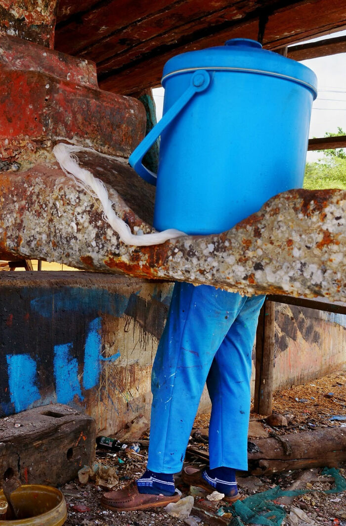 A street coincidence where a blue container aligns perfectly with a person’s blue pants in an urban setting.