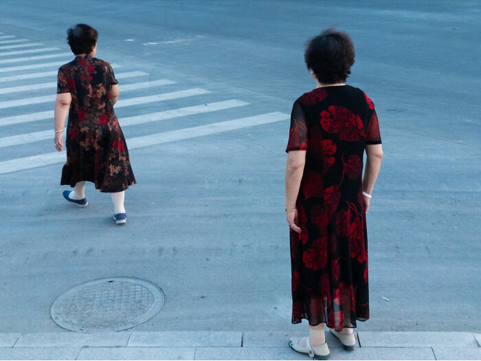 Two women wearing similar patterned dresses captured in a street coincidence showcasing unique street coincidences.