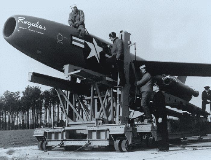 Black and white photo of military personnel inspecting a large missile labeled Regulus, showcasing historical weapons technology.