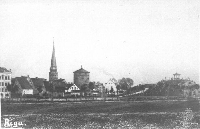 Historic black and white photo showing Riga, one of the world’s capitals, way before modern times with old buildings and a spire.
