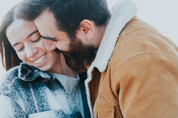 Pregnant wife smiling and close with husband while discussing baby name inspired by childhood dog Lassie.