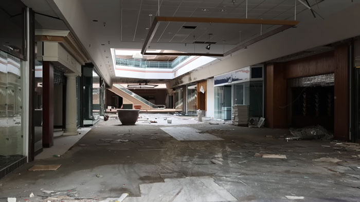 Abandoned ghost mall interior with debris and dim lighting where urban explorers found a trapped dog needing rescue.