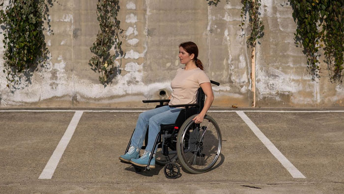 Teen girl in wheelchair outdoors, representing a disabled teen facing challenges in friendships and personal growth.